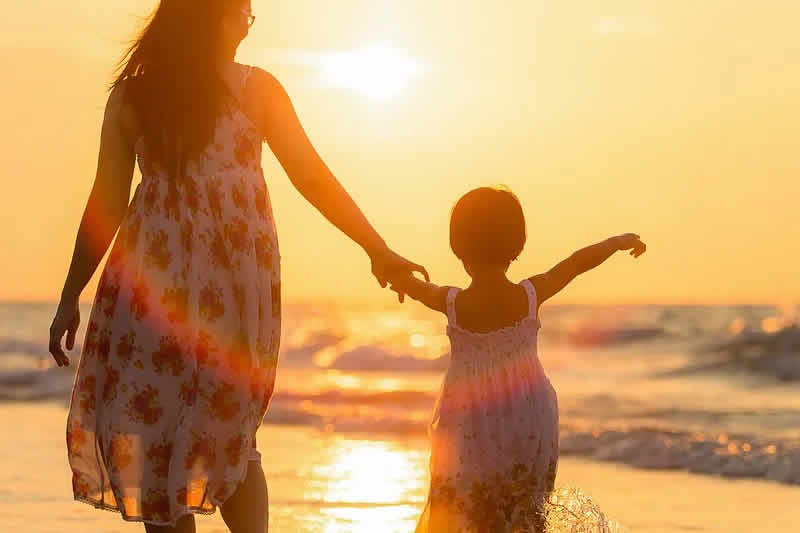 a mother holding her child's hand watching sunset : Mother's guilt